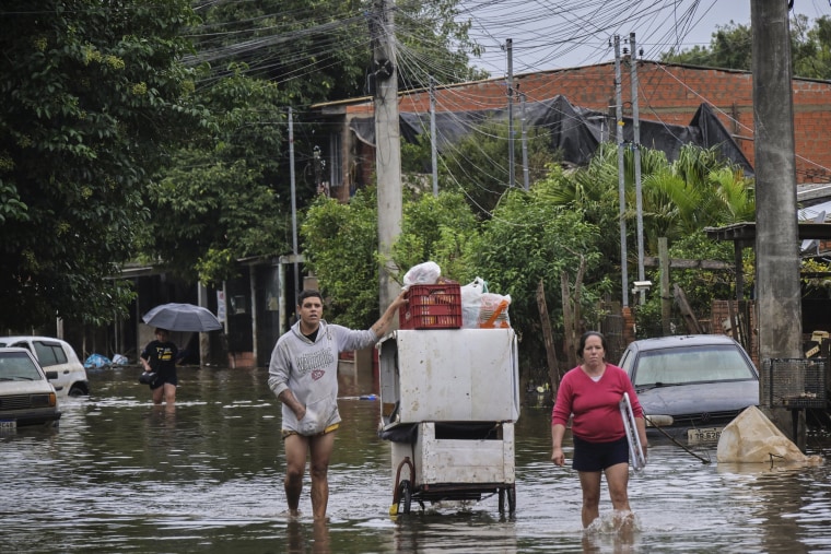Residents remove their belongings from their flooded homes in Brazil