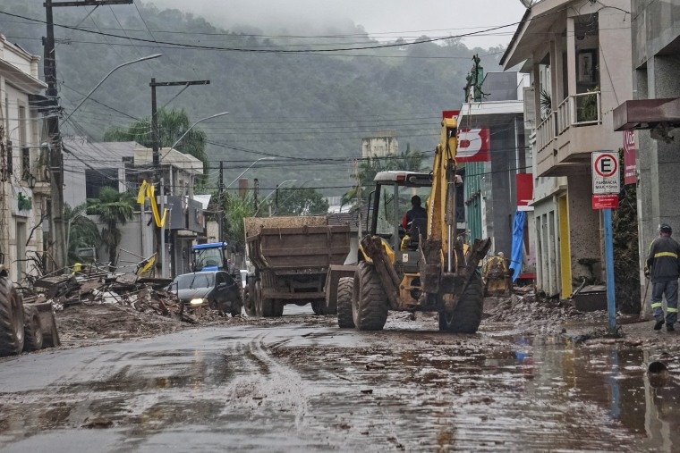 A worker cleans a street with a backhoe in Mucum, Brazil