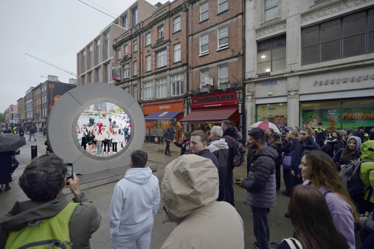 People in Dublin view the livestream portal with New York 