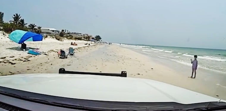 A sheriff's deputy approaches a lost girl on Indian Rocks Beach in Florida.