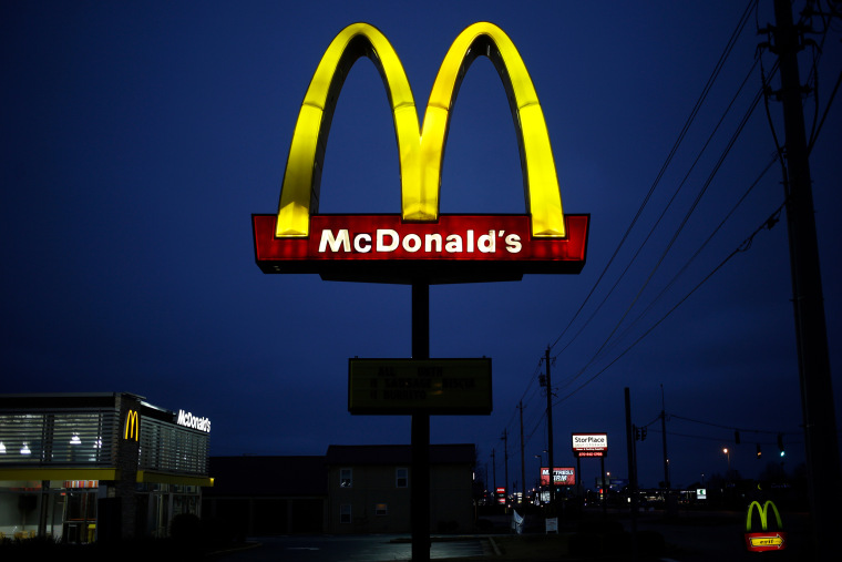 Signage stands outside a McDonald's restaurant at night