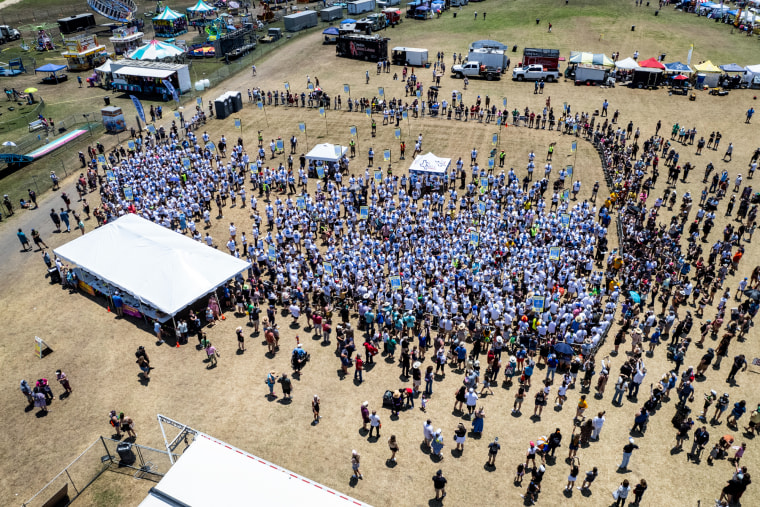 A drone overhead image of over 700 people gathered on a field