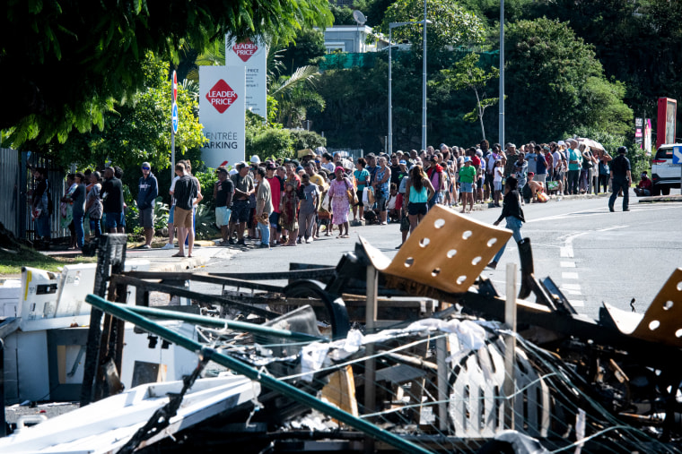 People wait in line to buy provisions.