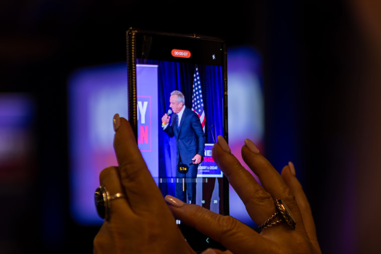 An attendee makes a video of  Robert F. Kennedy Jr. speaking at the rally