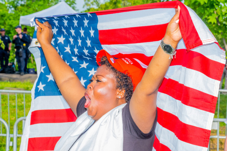An African American supporter holds up a flag