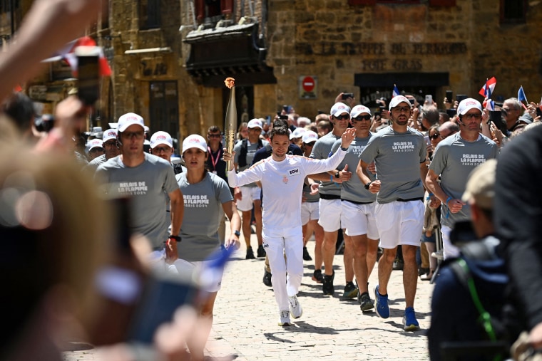French trail runner Paul Mathou runs with the flame during the Olympic torch relay.
