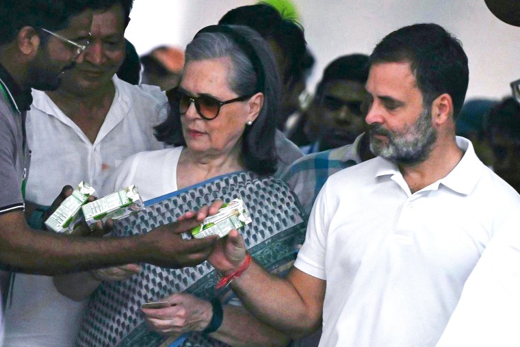 A volunteer gives packets of coconut water to Indian National Congress party leaders.