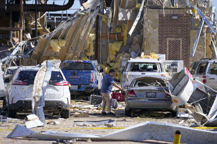 A man looks at a damaged car after a tornado hit the day before Sunday, May 26, 2024, in Valley View, Texas.