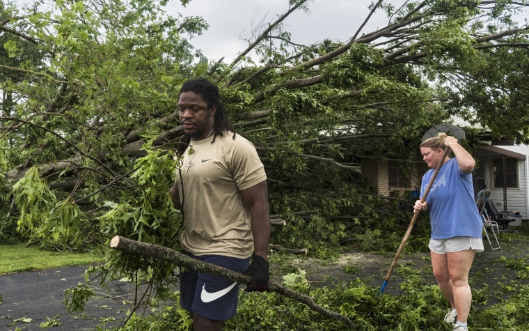 Will Worthey, left, and Lindsey Worthey of Rogers, Ark., help clear debris from a downed tree Sunday.