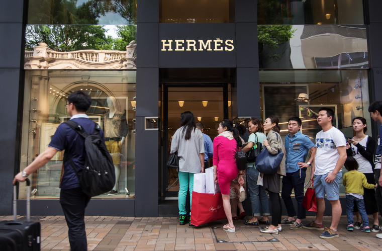 Shoppers line up to enter an Hermes International SCA store on Canton Road in the Tsim Sha Tsui area of Hong Kong.