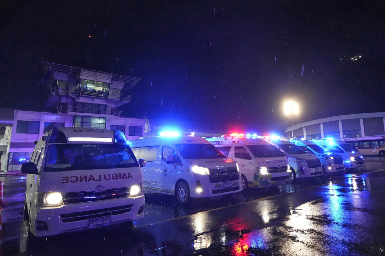 Ambulances wait to carry passengers from a London-Singapore flight that encountered severe turbulence, in Bangkok