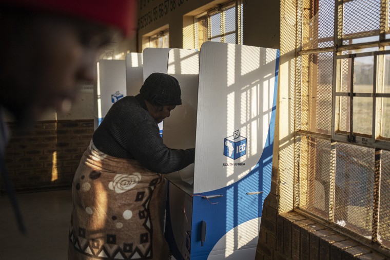 A woman marks her ballot in a voting booth at the Intlonipho Primary School polling station in Orange Farm, South Africa.