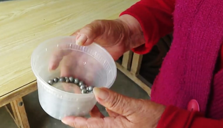 An Azusa resident holds ball bearings she says were shot at her house over the years.