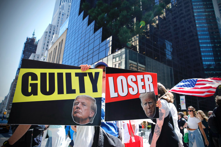 Protesters holding signs outside of Trump Tower in New York City,