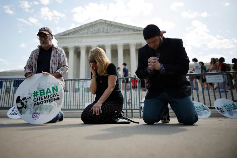 Anti-abortion activists pray in front of the Supreme Court