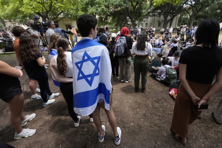 Un estudiante envuelto en la bandera de Israel escucha a manifestantes propalestinos en el recinto de la Universidad de Texas, en Austin, Texas, el 30 de abril de 2024.
