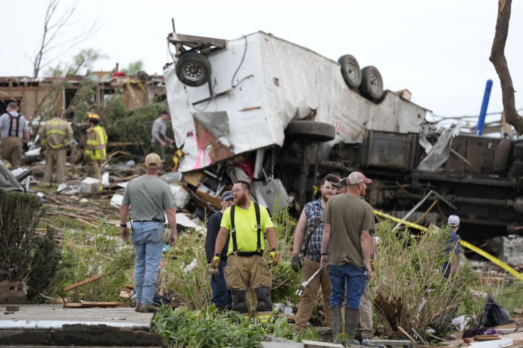 Trabajadores buscan entre los restos de una propiedad dañada por un tornado, el martes 21 de mayo de 2024, en Greenfield, Iowa.