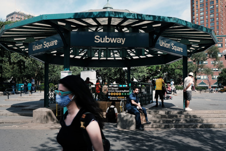 people walking around union square subway station with mask. 