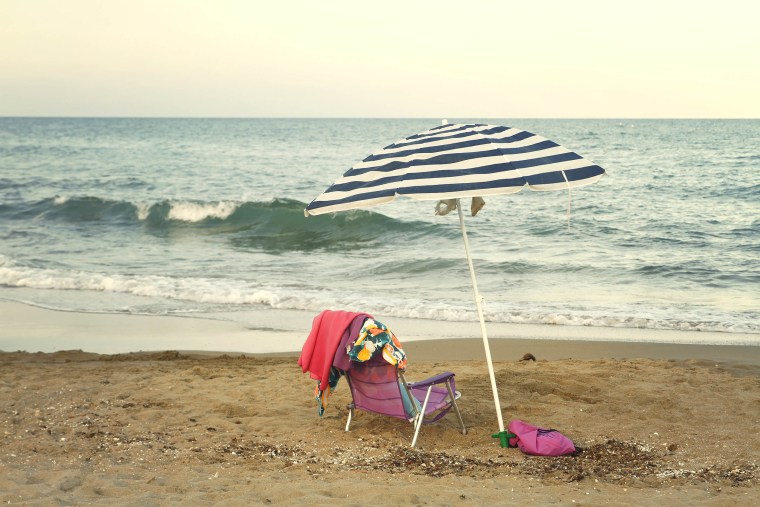 Beach umbrella and chair on sand at beach