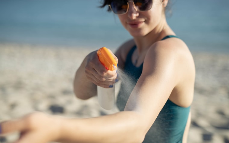 Woman applying sunscreen at beach