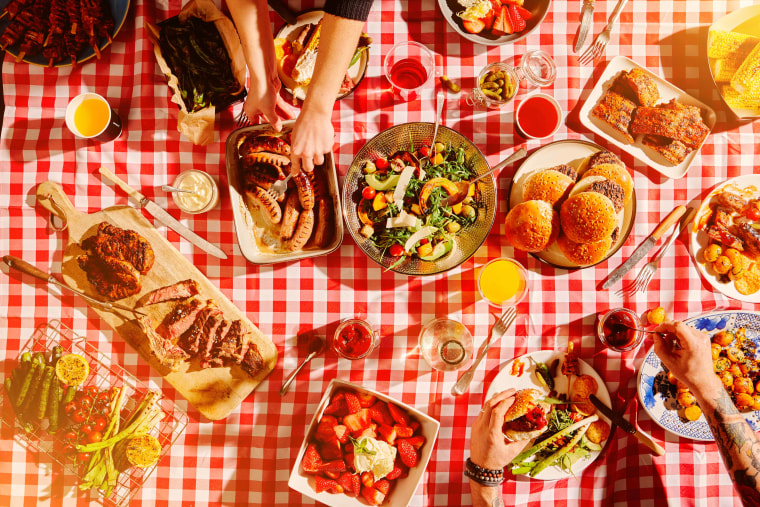 Top view of food, hands and people at barbecue on picnic blanket.