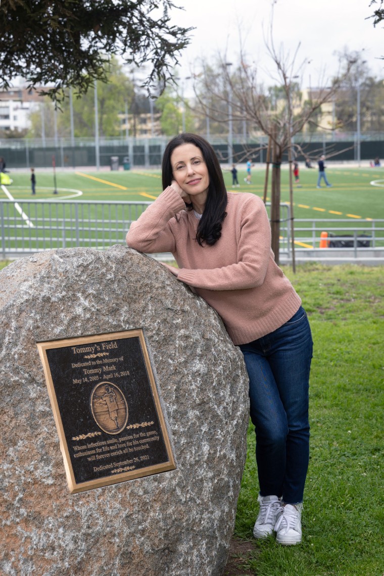 Nikki Mark posing with plaque for her son, Tommy.