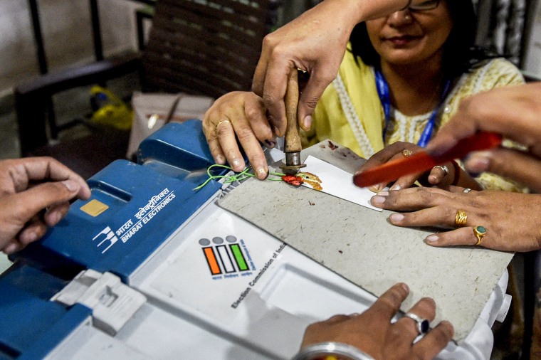 Polling officials seal Electronic Voting Machines.