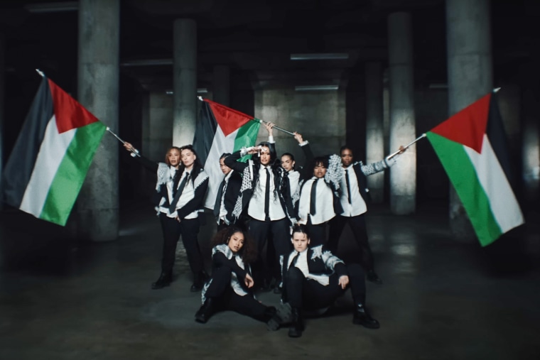 Kehlani and her backup dancer hold Palestinian flags and wear keffiyehs
