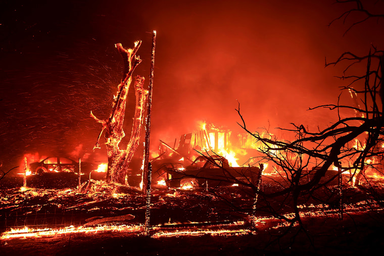 A home, car and trees on fire with smoke billowing