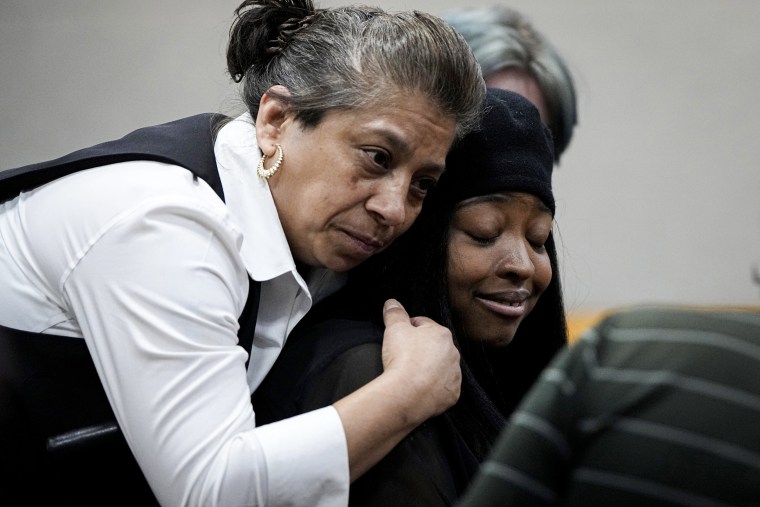 Whitney Mitchell, right, receives a hug from a friend.