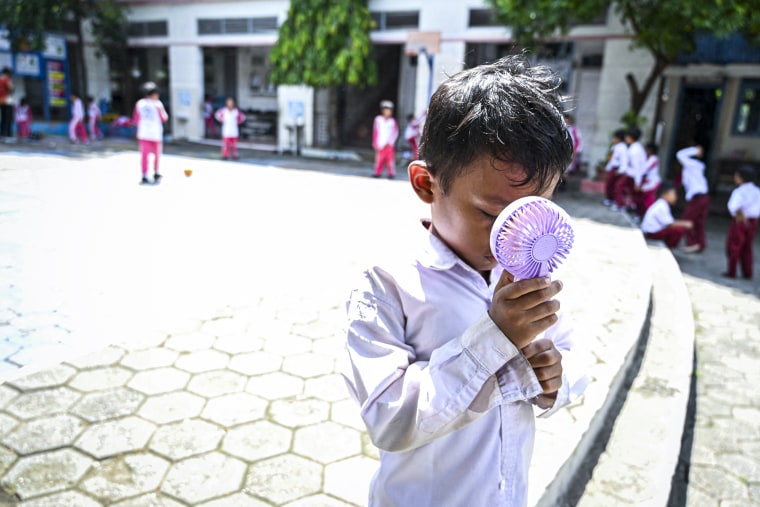 A student uses a portable fan to keep cool.