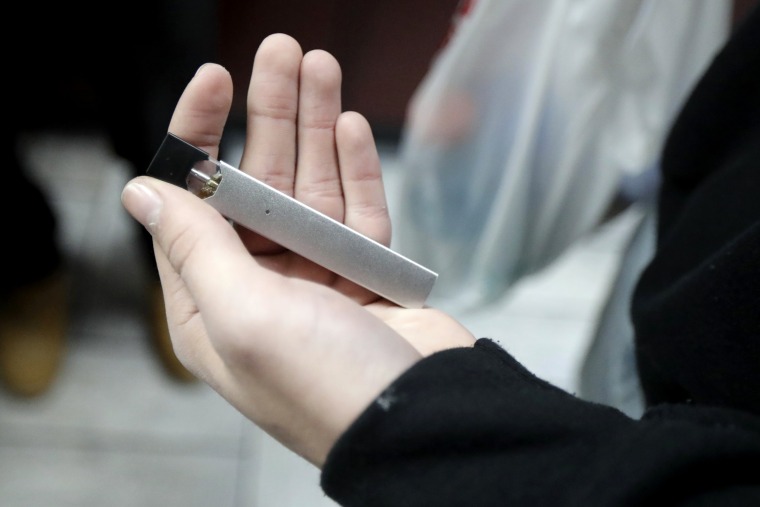 A man displays his Juul electronic cigarette while shopping at a convenience store in Hoboken, N.J.