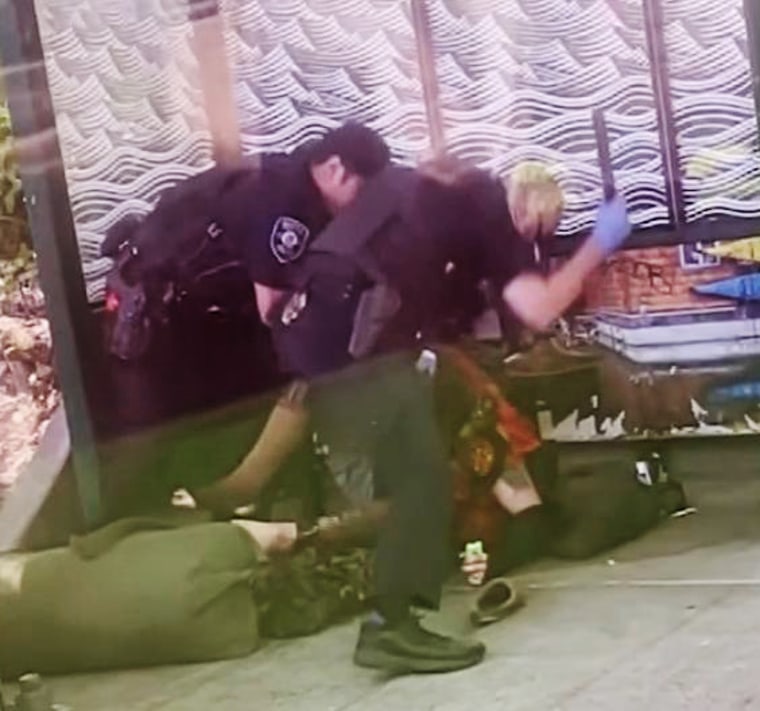 A Seattle police officers beats a man with a baton at a south Seattle bus stop on May 31, 2024.