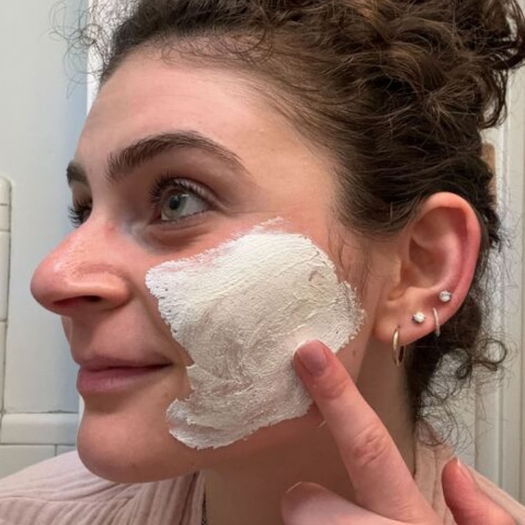 NBC Select associate updates editor Zoe Malin applies the Philosophy Purity Made Simple Pore Extractor Exfoliating Clay Mask to her left cheek.