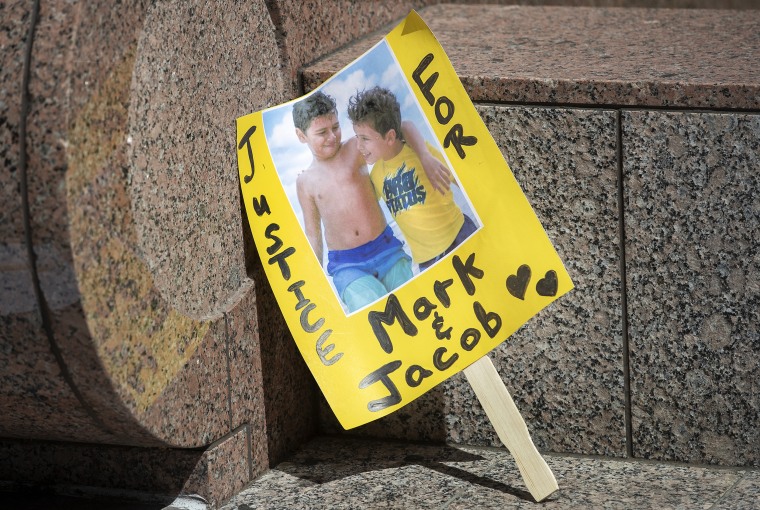 A sign shows an image of  Mark Iskander, 11, left, and his brother Jacob Iskander, 8,