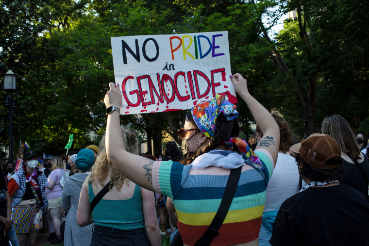 An activist holding a sign with No Pride in Genocide