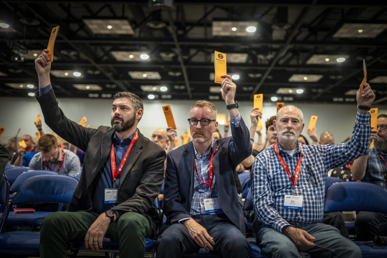 Image: Messengers raise their ballots in support of a motion put up for vote during a Southern Baptist Convention 
