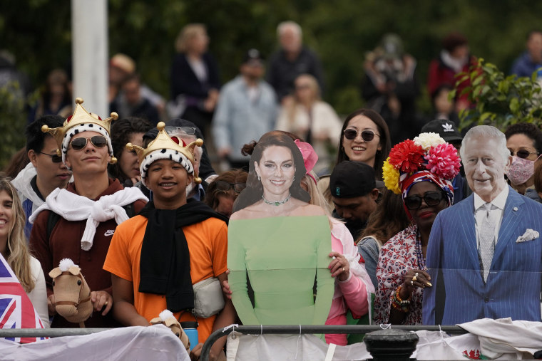 Royal fans hold up cut-out pictures of Britain's King Charles III and Kate, Princess of Wales as they gather in the Mall ahead of the start of the Trooping the Color ceremony in London, Saturday, June 15, 2024.