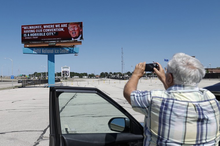 A man photographs a billboard launched by the Democratic National Committee in 10 Milwaukee locations on June 14, 2024 in Milwaukee.