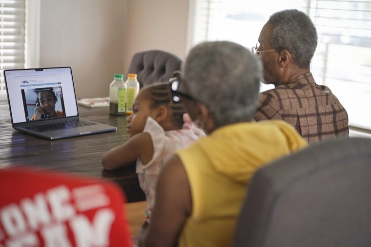 Reekila Harris-Dudley, seen on a laptop, speaks during a video call to her family members in their dining room