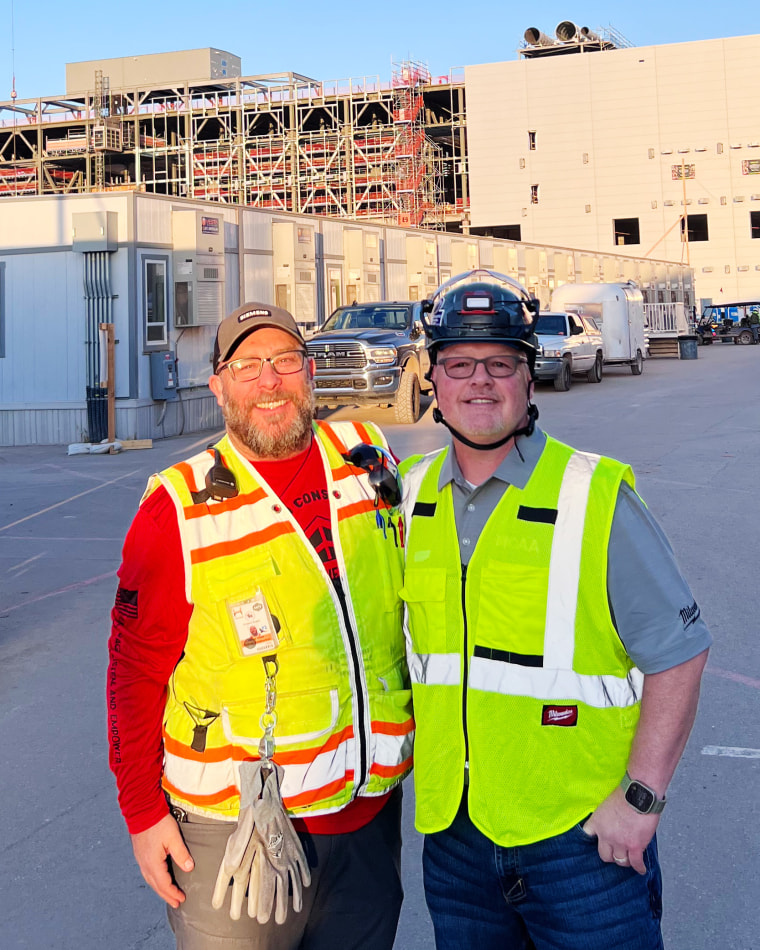 Josh Vitale and Justin Azbill in front of a construction site