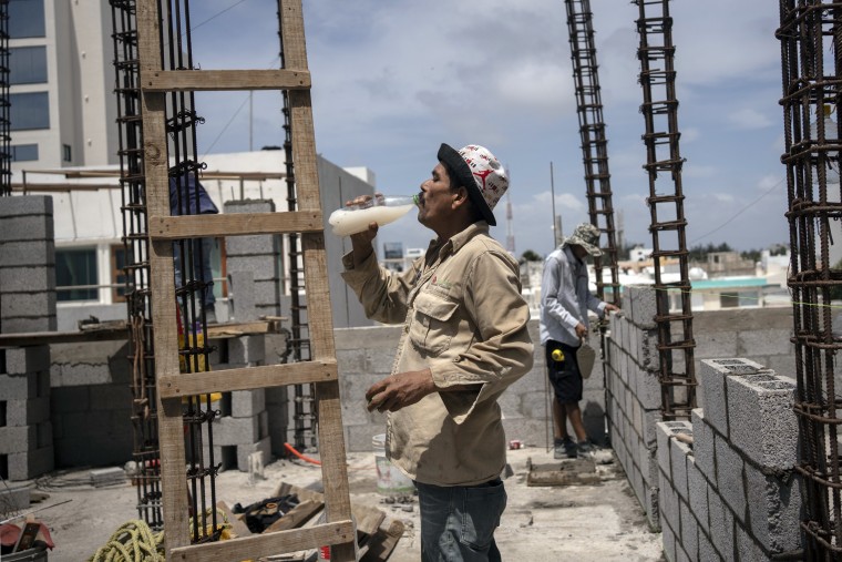 Jorge Moreno, a worker, drinks flavored water to cope with the heat wave during his workday at a construction site in Veracruz, Mexico