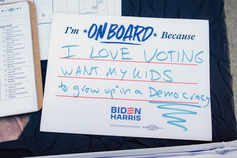 A Biden campaign poster reads: "I'm onboard because I love voting. Want my kids to grow up in a democracy."
