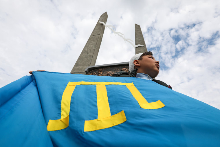 A person holds a Crimean flag during a rally