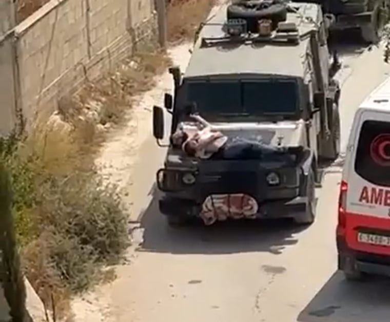 A still from a video showing a Palestinian man tied to the hood of an Israeli military vehicle in the occupied West Bank.