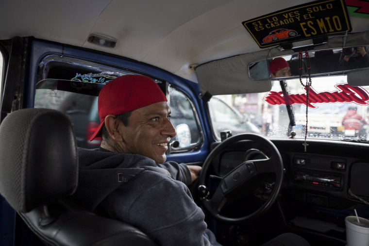 Taxi driver Claudio Garcia sits inside his Volkswagen Beetle he has named "Gualupita", in Mexico City