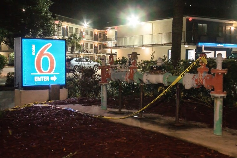 The exterior of a Motel 6 location, showing the sign out front and police tape