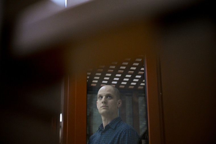 Evan Gershkovich looks out from inside a glass defendants' cage prior to a hearing in Sverdlovsk Regional Court, in Yekaterinburg, Russia