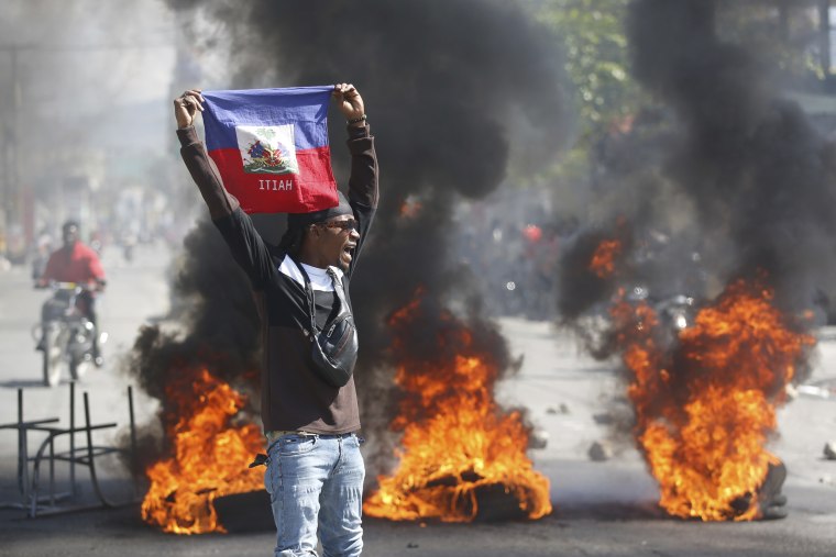 A demonstrator holds up a Haitian flag during protests in Port-au-Prince, Haiti