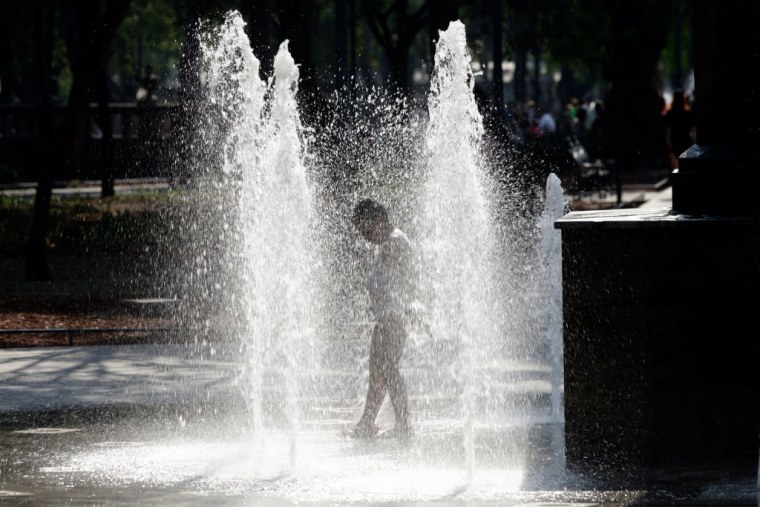 Un niño juega en una fuente del centro histórico de la Ciudad de México, para refrescarse de las altas temperaturas.